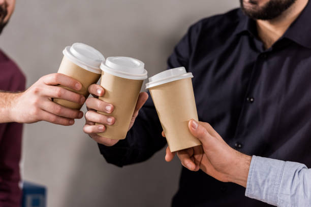 istock cropped image of businessmen clinking with disposable coffee cups 898117712