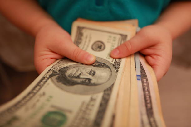 istock dollars in the hands of a child 898137510