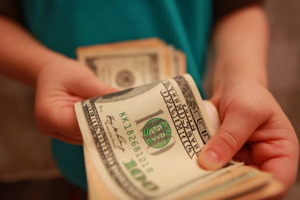 istock dollars in the hands of a child 898137518