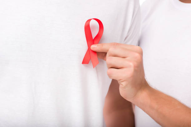 istock man attaching aids ribbon on t-shirt 898153316