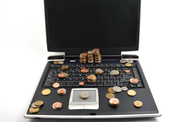 istock Coins on a laptop isolated on white background 898159586