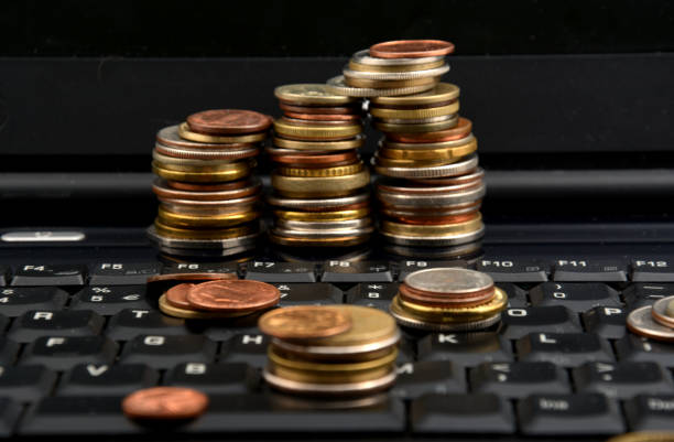 istock Coins on a laptop isolated on white background 898159614