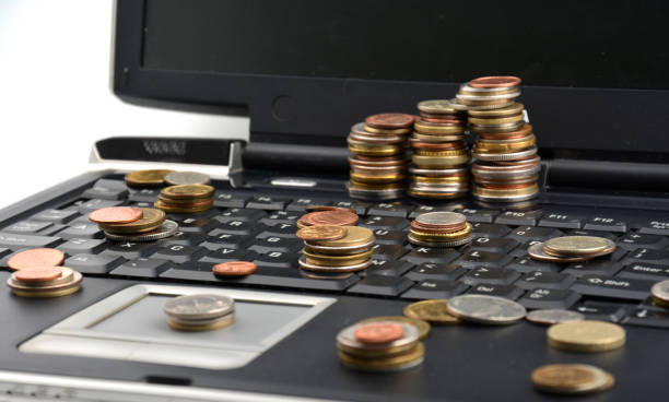 istock Coins on a laptop isolated on white background 898159716