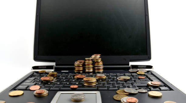 istock Coins on a laptop isolated on white background 898159830