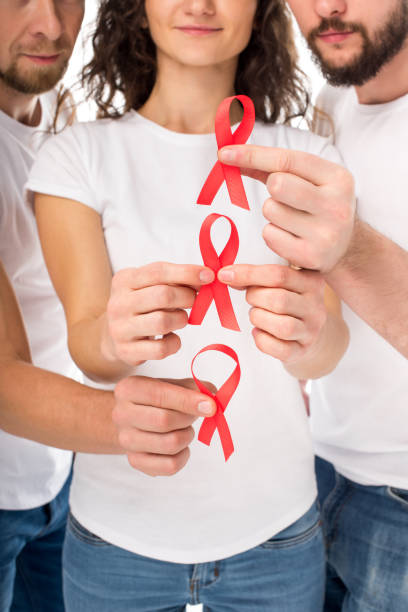istock people with aids ribbons in hands 898160102