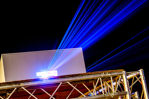dispositivo de proyección de láser con rayos largo azules en la noche photo