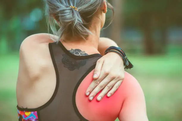 Woman holding her shoulder and back with red painful. Pain relief concept