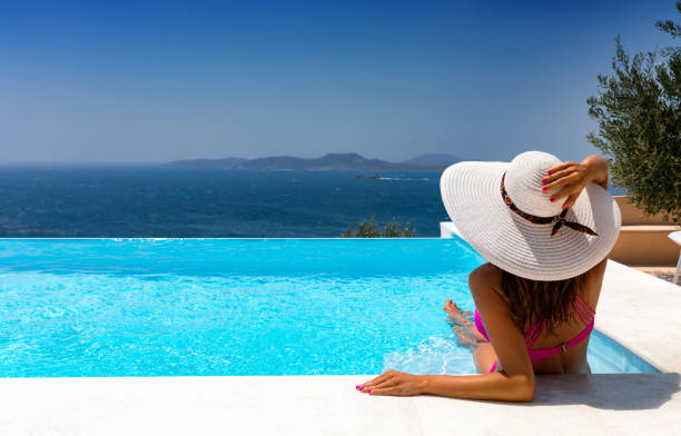 istock Attractive woman is relaxing in an infinity pool 898177052