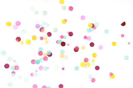 Multicolored confetti on white background. Festive backdrop for your design.