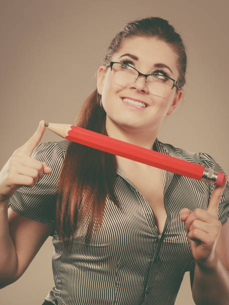 istock Teacher looking elegant woman holding big pencil 898185310