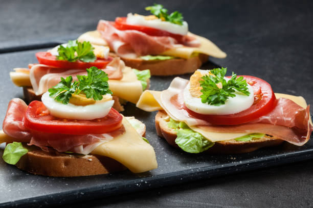 istock Delicious sandwich with prosciutto ham, cheese, tomato and egg 898197672