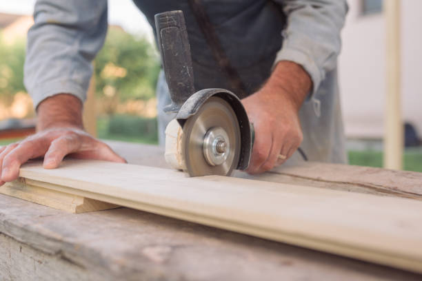 istock Man's hands cutting wooden plank with electric ripsaw 898200738