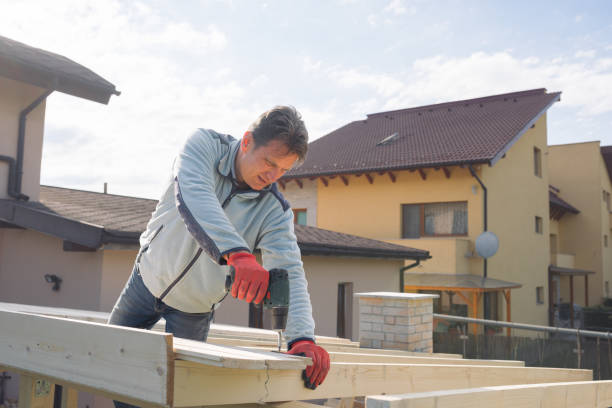istock Male constructor drilling wooden chalet roof 898206264