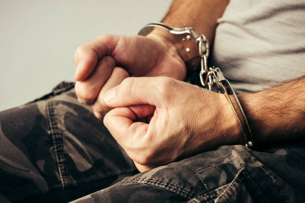 istock Handcuffed soldier in military army clothes 898207332