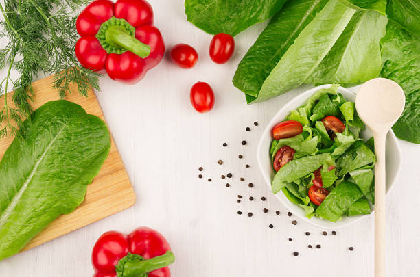 ingredients for healthy vegetarian spring salad -  fresh greens, tomatoes, spinach and paprika on white wood background, top view, copy space. - cooking oil olive oil nutritional supplement spoon imagens e fotografias de stock
