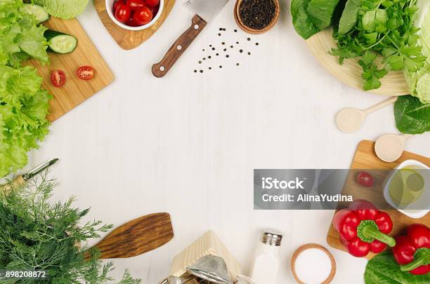 Healthy Eating Concept Fresh Raw Green Salad Cherry Tomatoes Paprika Spinach Cabbage And Olive Oil On White Wood Board Top View Stock Photo - Download Image Now