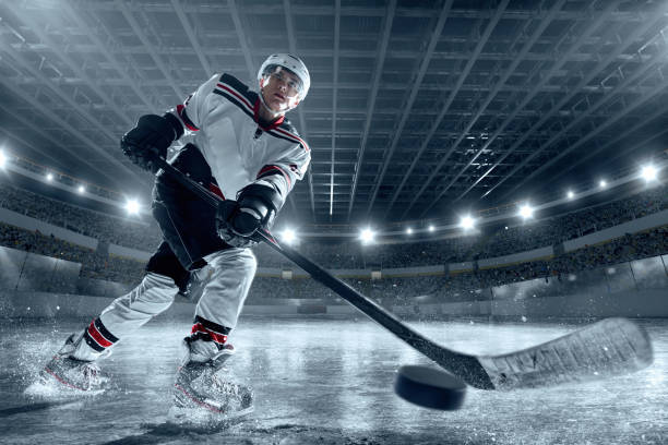 eishockey-spieler auf große professionelle eis-arena - ice hockey hockey puck playing shooting at goal stock-fotos und bilder