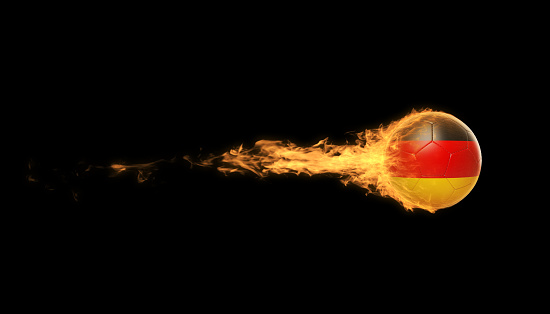 German soccer ball in flames over black background. Horizontal composition with copy space.
