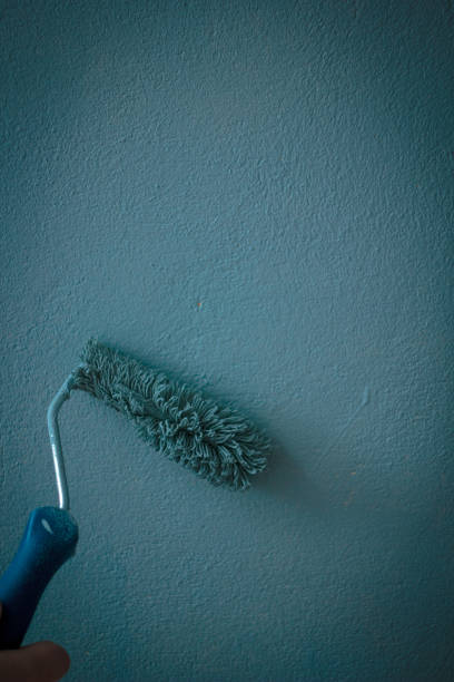 istock Painting wall by aqua color paints with paint roll. 898219646