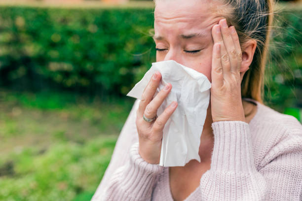 istock Young woman coughing covering her mouth with a tissue 898220100