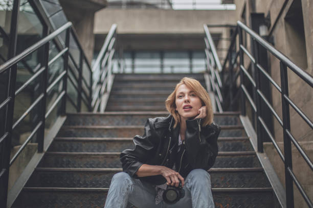 istock Young woman photographer sitting on steps 898230816