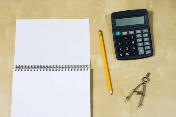istock Drawing instruments and a notebook on the work table. Accessories for designing and sketching on a wooden drawing board. White background. 898231774