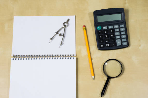 istock Drawing instruments and a notebook on the work table. Accessories for designing and sketching on a wooden drawing board. White background. 898231872