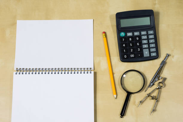 istock Drawing instruments and a notebook on the work table. Accessories for designing and sketching on a wooden drawing board. White background. 898231890