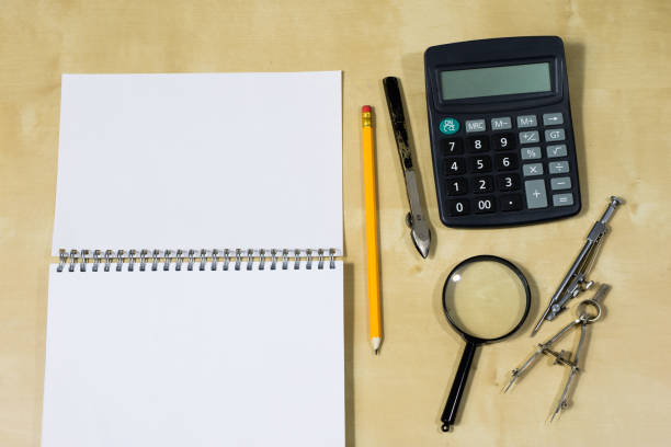 istock Drawing instruments and a notebook on the work table. Accessories for designing and sketching on a wooden drawing board. White background. 898232814