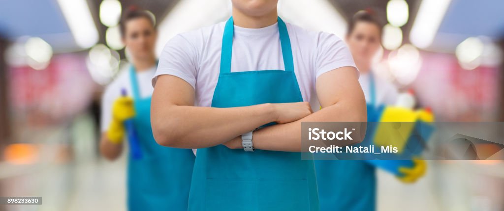 Group of cleaners standing on blurred background. Group of cleaners standing on blurred background. Concept cleaning service. Cleaning Stock Photo