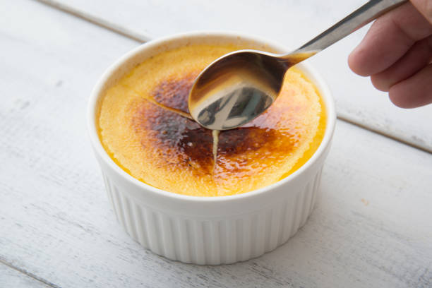 Preparing Homemade Creme Brulee with fresh blueberries