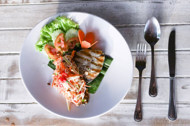 Baracuda steak with sauce and salad served in the fancy restaurant