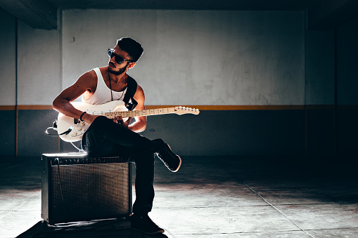 Red electric guitar on a wooden background. Empty space, close-up.