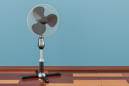 Standing pedestal electric fan in room on the wooden floor, 3D rendering