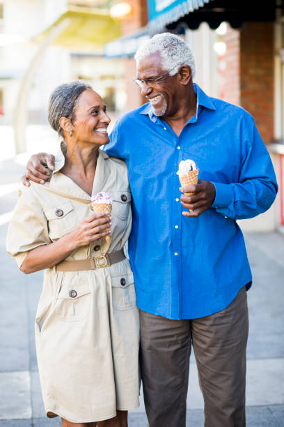 coppia senior afroamericana in città con gelato - laughing women shirt vertical foto e immagini stock