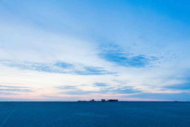 The stunning beach of St. Peter-Ording with some pile dwellings. This beach is located at the west coast of Schleswig-Holstein and is said to be the widest beach in Europe. In front a huge pile dwelling with a restaurant and a cafe. 50 Mpx image taken with Canon EOS 5Ds and EF11-24mm.