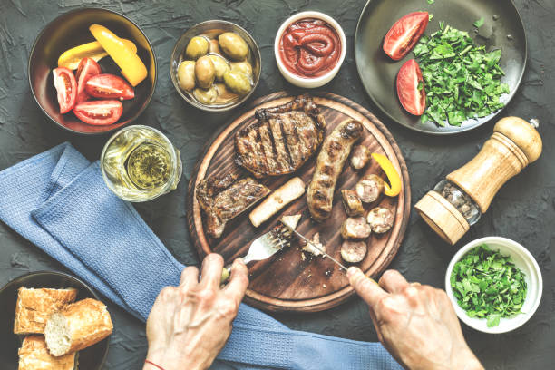istock Portion lunch. A la carte lunch. Fresh vegetables, a barbecue steak and various snacks.Man eats a juicy barbecue steak 898248118