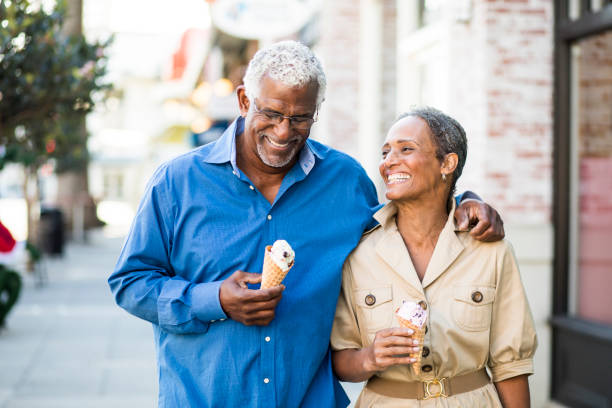 coppia senior afroamericana in città con gelato - retirement living foto e immagini stock