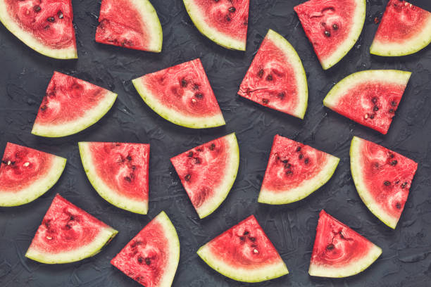 istock Slices of ripe watermelon on a black stone background 898248426