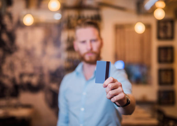 istock Young businessman holding a credit card. 898251400