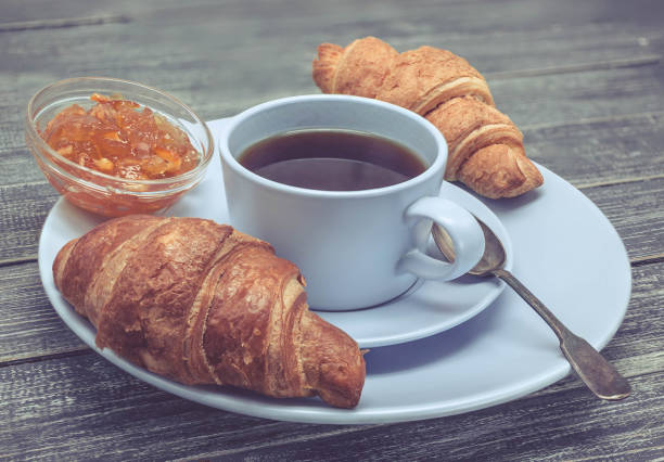 istock Croissant with orange jam and a cup of tea. Continental breakfast concept. Selective focus 898256038