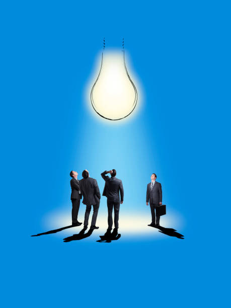 istock Group Of Businessmen Looking Up At Light Bulb That Shines On Them 898258404