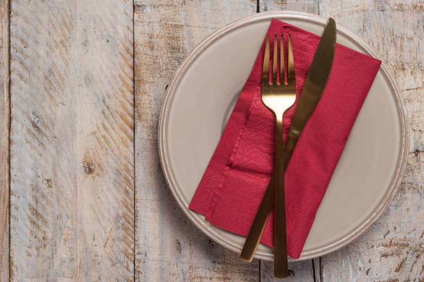 istock Table setting with plate golden fork and knife on wooden background 898261662