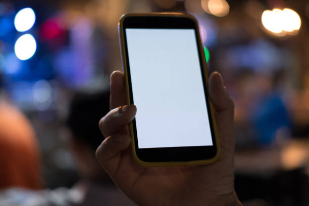 istock hand holding smartphone in pub. mobile phone with blank screen in restaurant 898262846