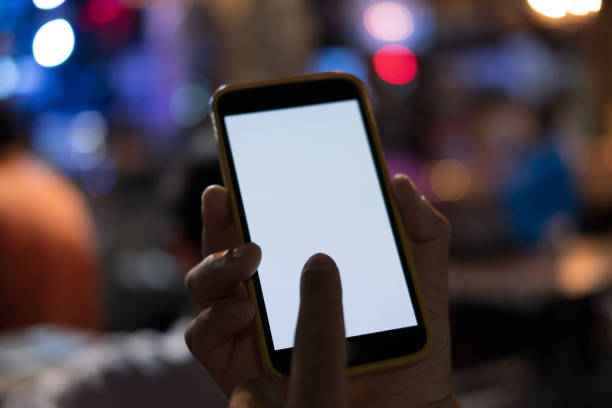 istock hand holding smartphone in pub. mobile phone with blank screen in restaurant 898262848