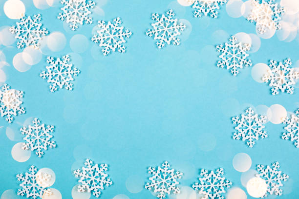 istock White toy snow flakes on blue background. 898264152