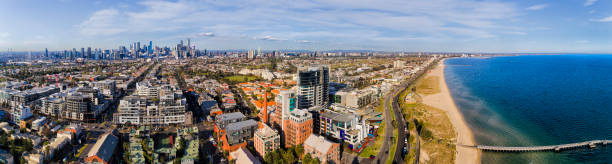 D Me Port Melbourne CBD 2 Beach pan Wide aerial panorama of POrt Melbourne residential suburb from Port Phillip bay beach waterfront to distant city CBD high-rise towers on a sunny day. port melbourne melbourne stock pictures, royalty-free photos & images