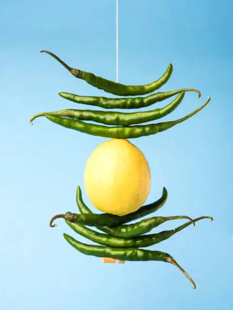 Photo of lemon chilies hanging - Indian superstitious lemon and green chillies tied with thread and tied on doors at home or shop to avoid any bad fortune also known as totka or nazar battu
