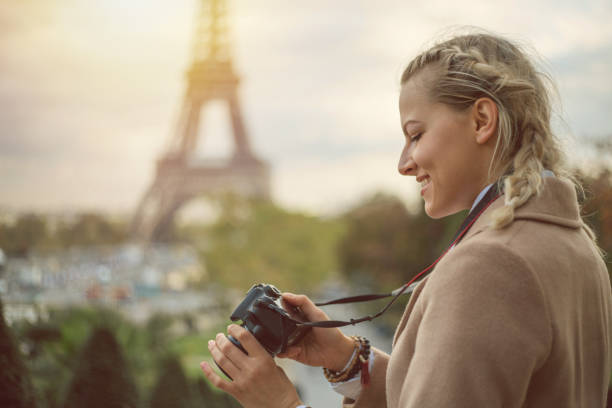 istock Young woman in Paris with camera in hands, checking pictures 898287580