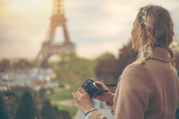 istock Young woman in Paris with camera in hands, checking pictures 898287584